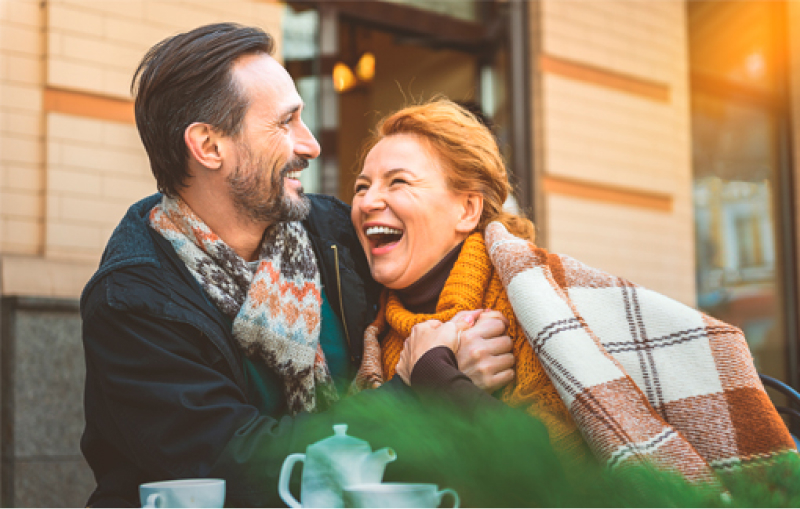 Pareja feliz tomando algo en una terraza